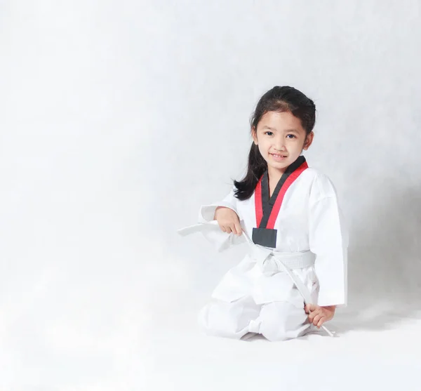 Feliz asiática niña sonrisa sentado y atar una línea blanca en ta — Foto de Stock