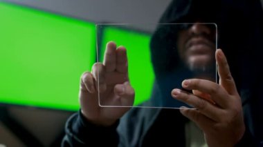Hacker açık cam tablet yeşil ekran monitör arkasında ve koyu tonu ile işlenmiş tahıl ile kullanma
