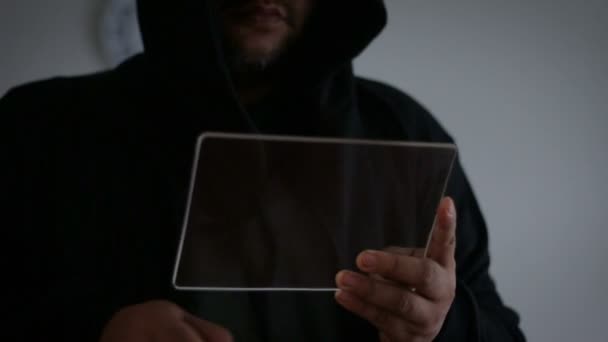 Hacker usando tableta de vidrio transparente con tono oscuro y grano procesado — Vídeos de Stock