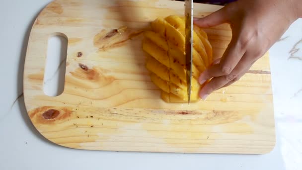 Bliska strzał ręce kobiety za pomocą noża do cięcia ananas płytkiej głębi ostrości — Wideo stockowe