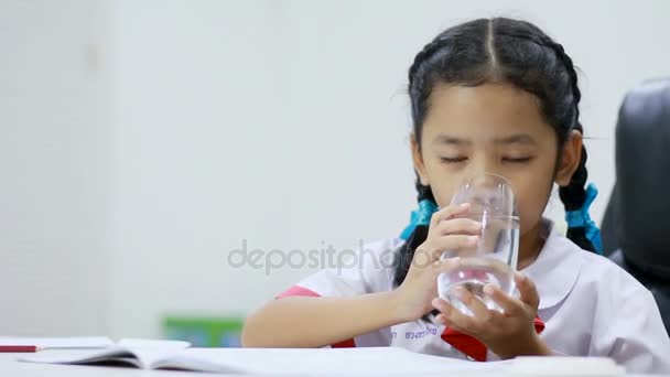 Asian little girl in Thai kindergarten student uniform drinking water close up shot — Stock Video