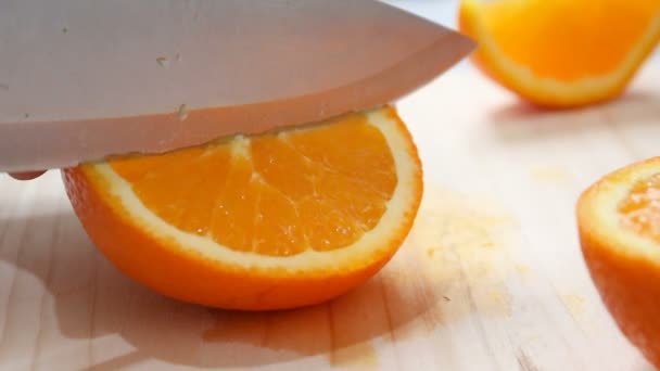 Közelről lövés kezében nő konyha kés segítségével csökkentse vágott friss, érett narancs fa vágó fórumon sekély mélység-ból mező — Stock videók