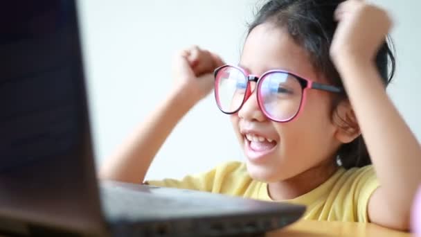 Азиатская девочка, использующая ноутбук компьютер со счастьем и весельем — стоковое видео