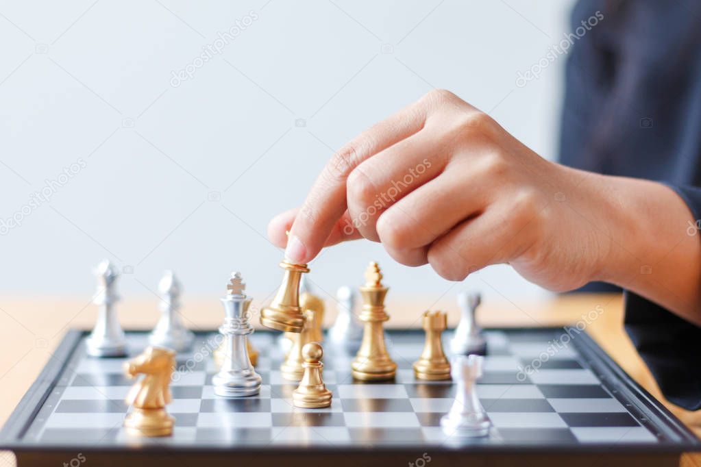Close up shot hand of business woman moving golden chess to defe