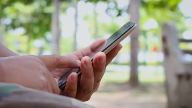  Ortam ses ile bir doğa Park mobil akıllı telefon kullanan adam shot el kadar kapatın