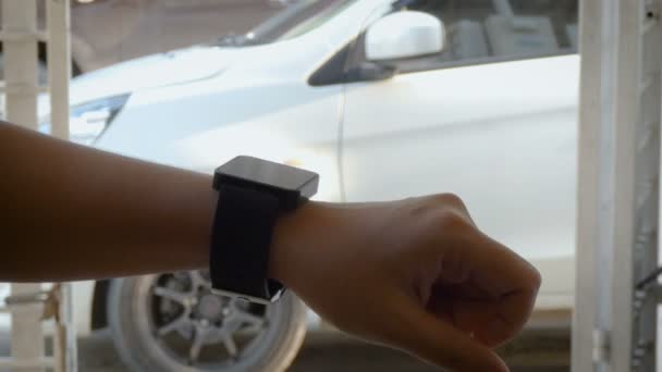 Руки жінки, використовуючи розумний годинник, щоб відкрити і закрити замок і розблокувати двері концепції автомобільної метафори віддаленої безпеки — стокове відео