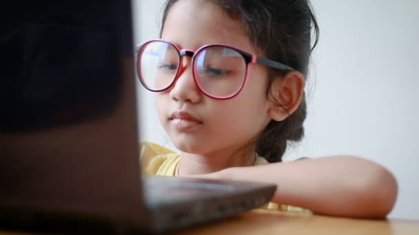 Азиатская девочка, использующая ноутбук со звуком — стоковое видео