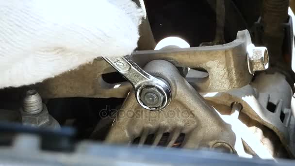 Mains de mécanicien à l'aide d'une clé à molette pour desserrer le boulon hexagonal du moteur de démarrage du moteur de voiture 