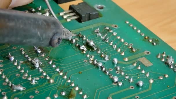 4k nära upp skott elektriska löda i lödning på elektroniska print circuit board med hett bly och rök med omgivande ljud — Stockvideo