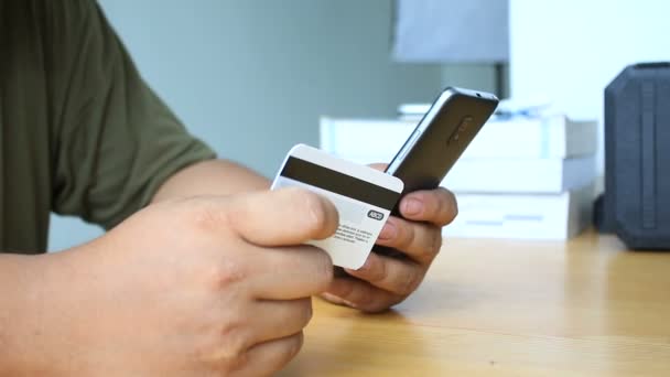 Primer plano de las manos del hombre utilizando el teléfono inteligente y la celebración de la metáfora de la tarjeta de crédito de compras por Internet aplicación móvil y el concepto de negocio electrónico — Vídeo de stock