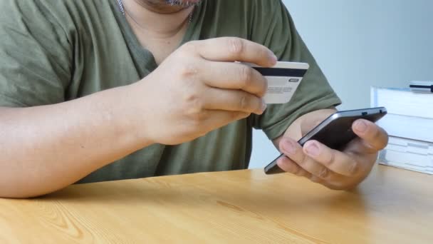 Közelről lövés kezét, az ember használ szúró telefon és hitelkártya metafora internet mobil alkalmazás vásárlási és e-üzleti koncepció — Stock videók