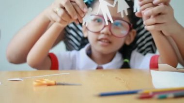 Tay anaokulu öğrenci üniforma çekim Asyalı küçük kız ve annesi Beyaz aile şekil baba anne oğul ve eller odaklanmak seçin kızı ahşap masa üzerine kağıt kesme oynarken kapatmak