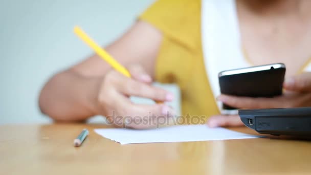 Руки жінки, що використовують мобільний смартфон та олівець, пишуть на паперовій метафорі онлайн-додаток та бізнес-маркетинг, обирають фокус на неглибокій глибині різкості — стокове відео