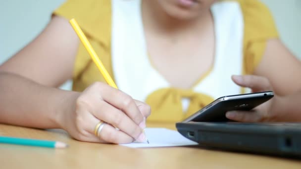 Les mains de la femme en utilisant le téléphone intelligent mobile et l'écriture au crayon sur la métaphore du papier application en ligne et marketing d'entreprise sélectionner se concentrer sur la main faible profondeur de champ — Video