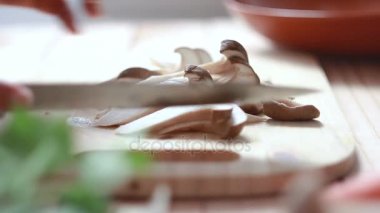 Kadının Eringi mantar yemek pişirmek için hazırlanıyor kesip mutfak bıçak slayt kullanarak atış eller yukarı kapatın 