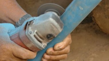 4k yakın çekim yukarı kaydırmak için elektrik değirmeni kullanan makinist adam elinde pvc boru ortam ses ile kesti.