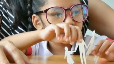 Tay anaokulu öğrenci üniforma çekim Asyalı küçük kız ve annesi kesilmiş beyaz aile şekil baba anne oğlu ve kızı üzerinde ahşap masa yapma kağıt oynamaya yakın