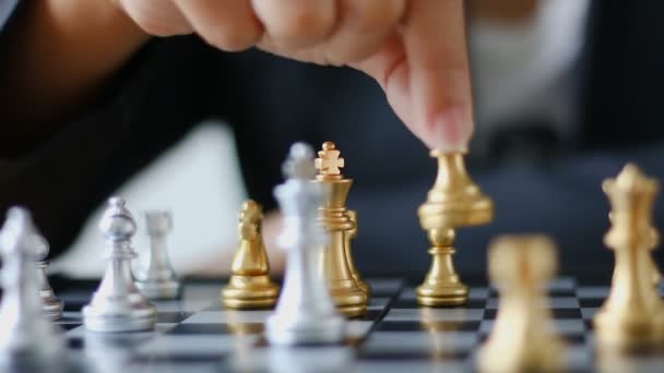 Primer plano manos de hombre y mujer de negocios moviendo ajedrez de oro y ajedrez de plata en juego de mesa de ajedrez para ganador y perdedor negocio desafío metáfora y concepto de competencia de negocios — Vídeo de stock