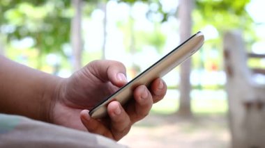 Ortam ses ile bir doğa Park mobil akıllı telefon kullanan adam shot el kadar kapatın