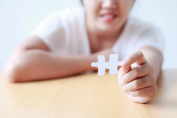 Asiatin zeigt Puzzle flache Schärfentiefe auswählen — Stockfoto