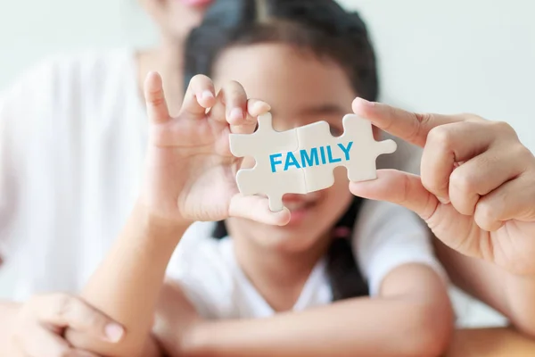 Asian little girl playing jigsaw puzzle with her mother for fami — Stock Photo, Image
