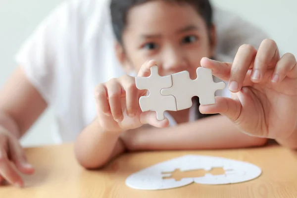 Asian little girl playing jigsaw puzzle with her mother for fami — Stock Photo, Image