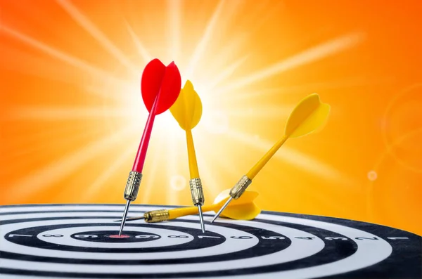 Close up shot red dart arrow on center of dartboard and yellow a — Stock Photo, Image