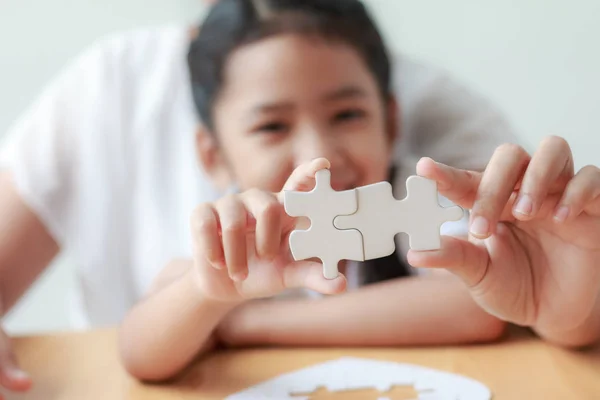 Asian little girl playing jigsaw puzzle with her mother for fami — Stock Photo, Image