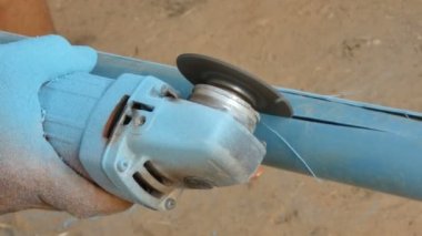 Tamirci adamın elektrik değirmeni slayt kullanarak atış eller yakından ortam ses ile pvc Boru kesme