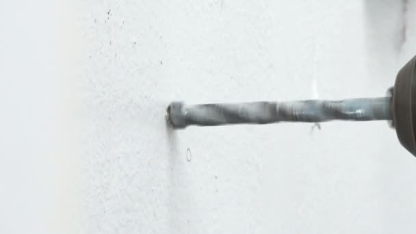 クローズ アップ ショット音が周囲にホールドのセメント コンクリートの白い壁を掘削ビット電気ベルト グラインダー スピン — ストック動画