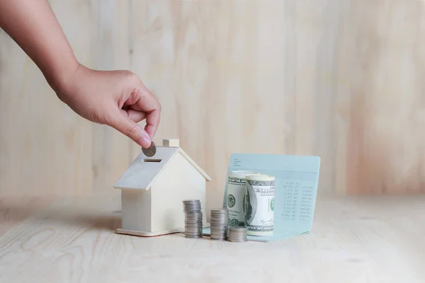 Kvinna hand sätta myntet i för trähus spargris finansnetto — Stockfoto