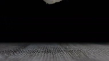 Ahşap masa againts siyah arka plan üzerine düşen ağır çekim sarımsak