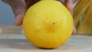 Kadının mutfak bıçak dilim kesip taze limon ahşap kesme tahtası üzerinde kullanarak atış eller yukarı kapatın