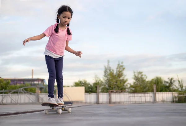 Asiática niña jugando monopatín seleccionar foco superficial profundidad — Foto de Stock