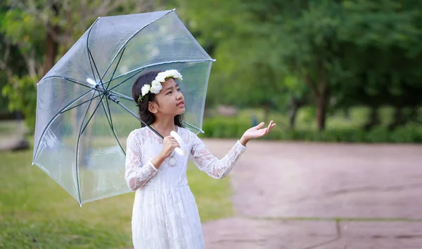 Little Asian girl holding clear umbrella and smiling with happin — Stock Photo, Image