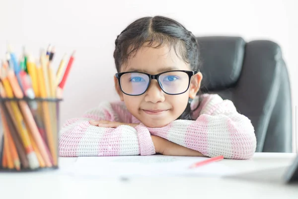 Liten asiatisk tjej gör läxor och leende med lycka för Ed — Stockfoto