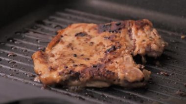 Sıcak tavada yakın çekim pişirme ve ızgara domuz bifteği, seçtiğiniz odak derinliği sığ alan