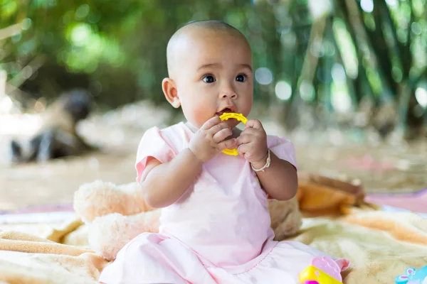 Niedliche kleine asiatische Baby sitzen und spielen mit Glück auswählen fo — Stockfoto