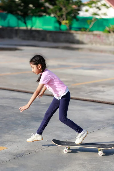 Asiática niña jugando monopatín seleccionar foco superficial profundidad — Foto de Stock