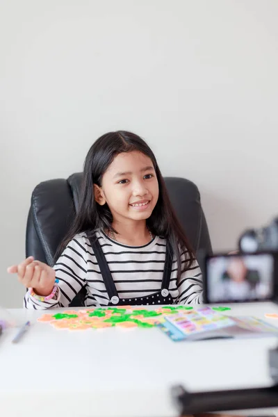 Joyeux petit asiatique fille assis à la table blanche et live ster — Photo