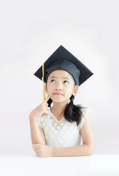 Portrait little Asian girl is wearing graduate hat and smile wit — Stock Photo, Image