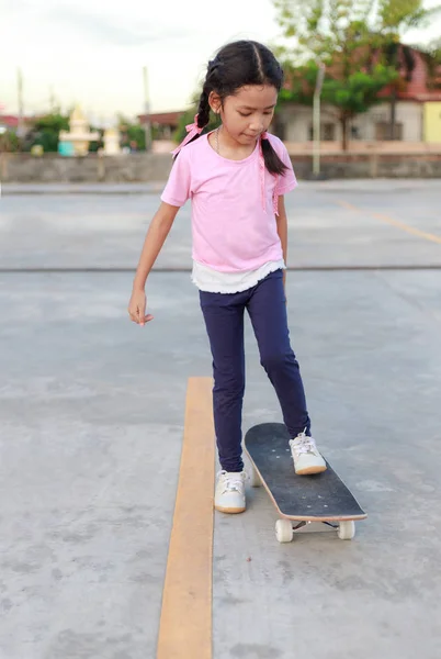 Azji mała dziewczynka gra na deskorolce wybierz ostrość płytkiej głębokości — Zdjęcie stockowe