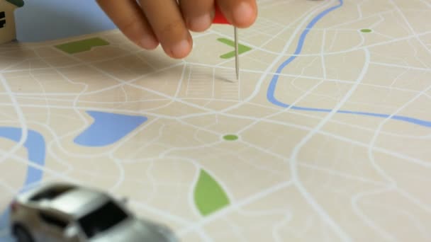 Gros plan main d'enfants clouant la broche cible à la carte, destination métaphore du voyage et du voyage, sélectionner focus faible profondeur de champ 