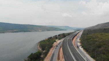 İnsansız hava aracı, inşaat altındaki otoyol ve karayolu, neredeyse doğal büyük nehir dağı ve orman köprüsünün manzaralı manzarasını çekti.