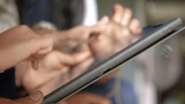 Tablet kullanan büyükanne ve çocuğun elleri, metafor ve yaş farkı ile mobil teknolojinin nasıl kullanılacağını öğrenen bir ailenin elleri, yüzeysel alan derinliğini seçin