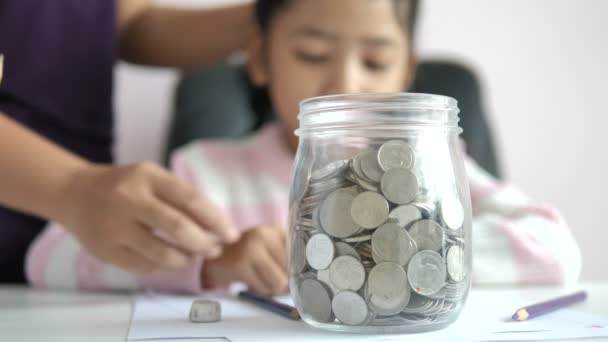 Asiática Niña Poniendo Moneda Frasco Vidrio Poco Profunda Profundidad Campo — Vídeos de Stock