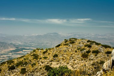 Mavi gökyüzünün altında çimenleri olan bir sürü yüksek dağ