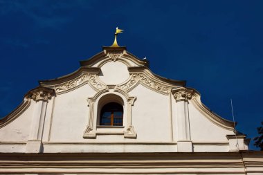 Mavi gökyüzünün arka planında küçük bir penceresi olan çatı