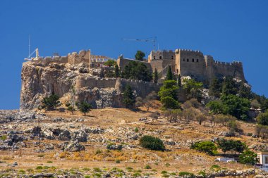 Gökyüzüne karşı yüksek bir dağın tepesindeki antik kale