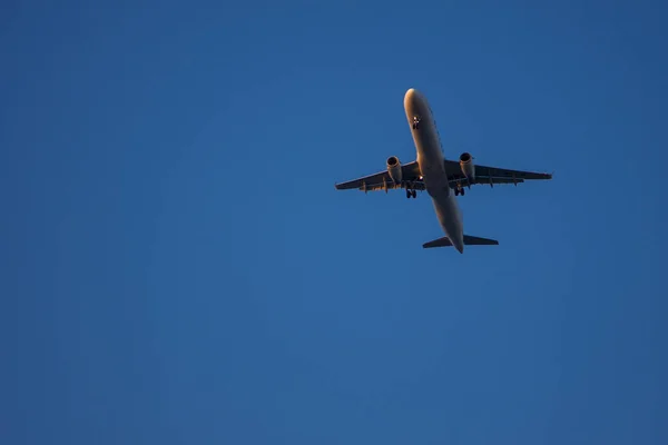 Ένα Αεροπλάνο Πετάει Μέσα Από Τον Γαλάζιο Ουρανό — Φωτογραφία Αρχείου